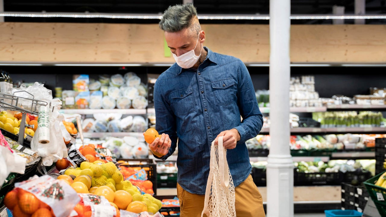 Middle-aged man shopping for oranges at a grocery store