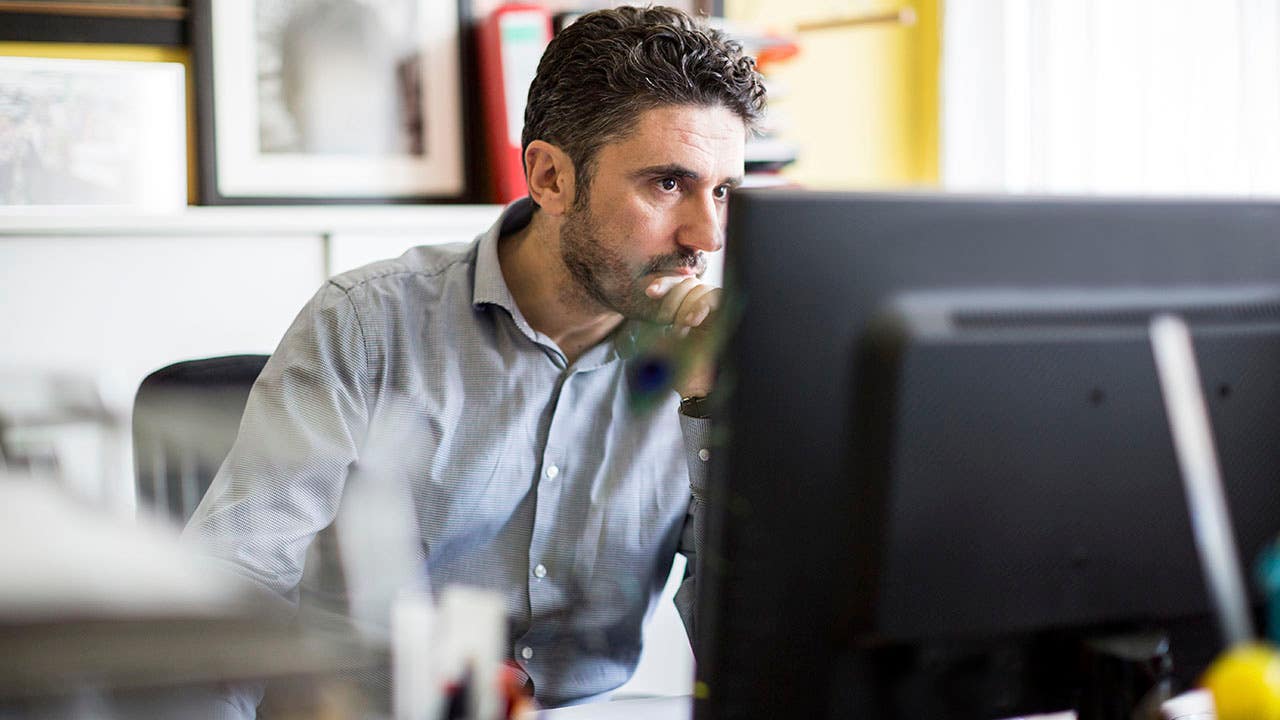 A man looking at a computer screen in an office