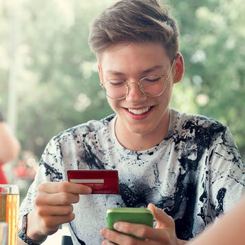 teenage boy using a credit card at a restaurant