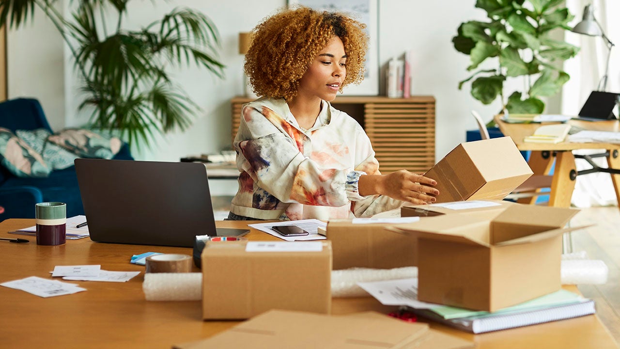 businesswoman taping and packing shipping boxes