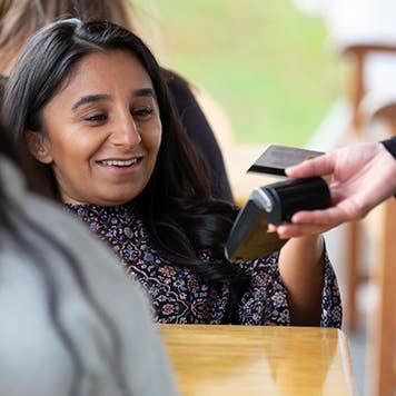 Woman making payment with credit card in cafe