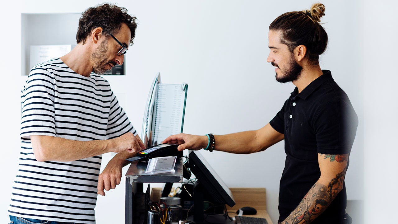 Male customer paying through credit card at hair salon