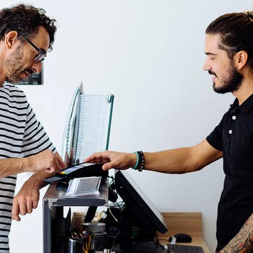 Male customer paying through credit card at hair salon