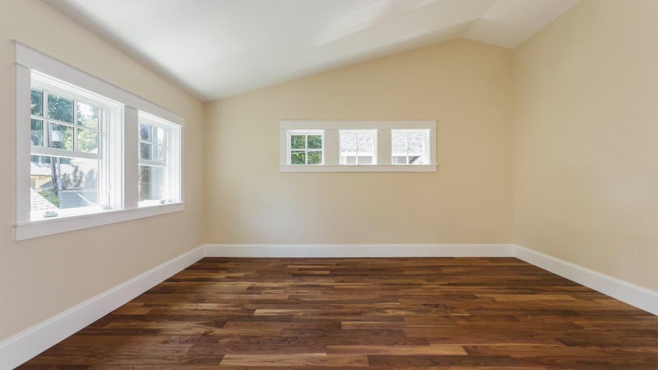 Wooden floor and bare walls in empty bedroom