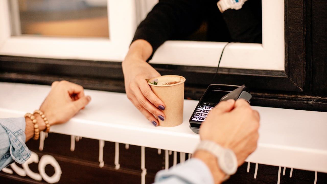hands of customer paying with credit card to buy coffee