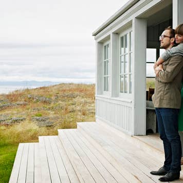 Young couple embracing on porch of home