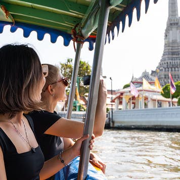 two women riding a boat in bangkok
