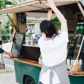 man and woman opening the side window of a food truck