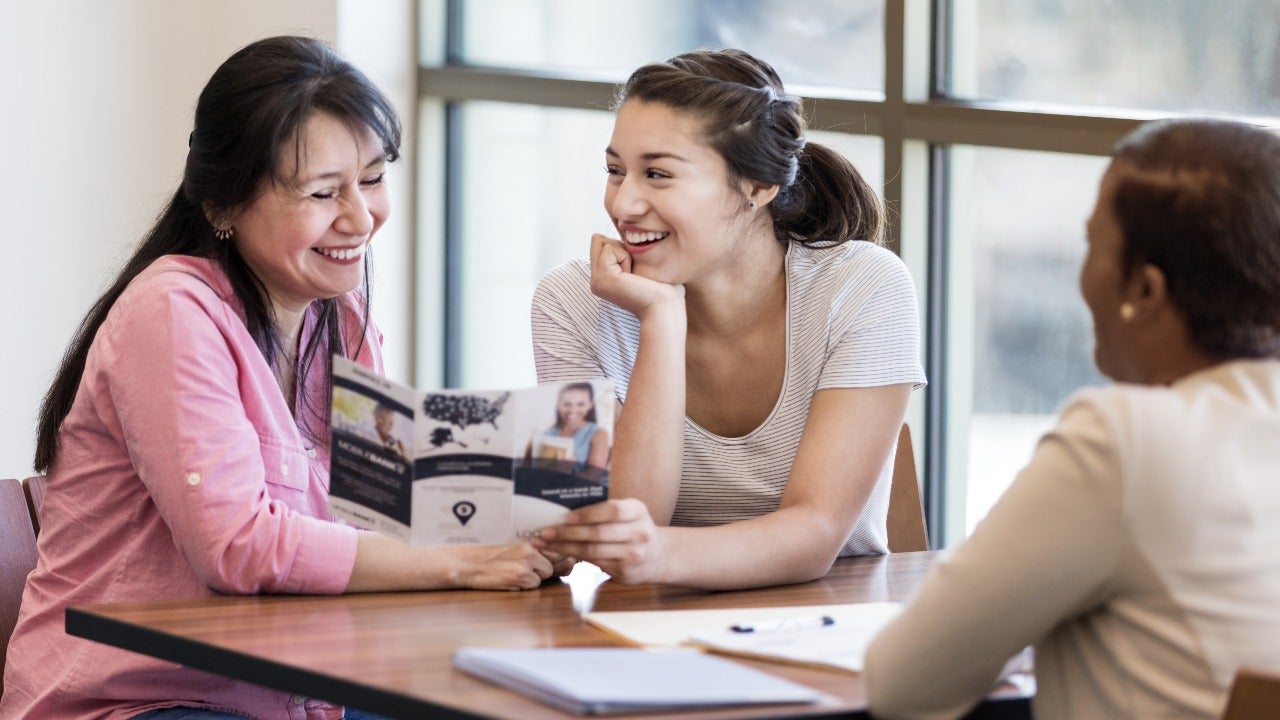 Mother and daughter look at pamphlet for a loan