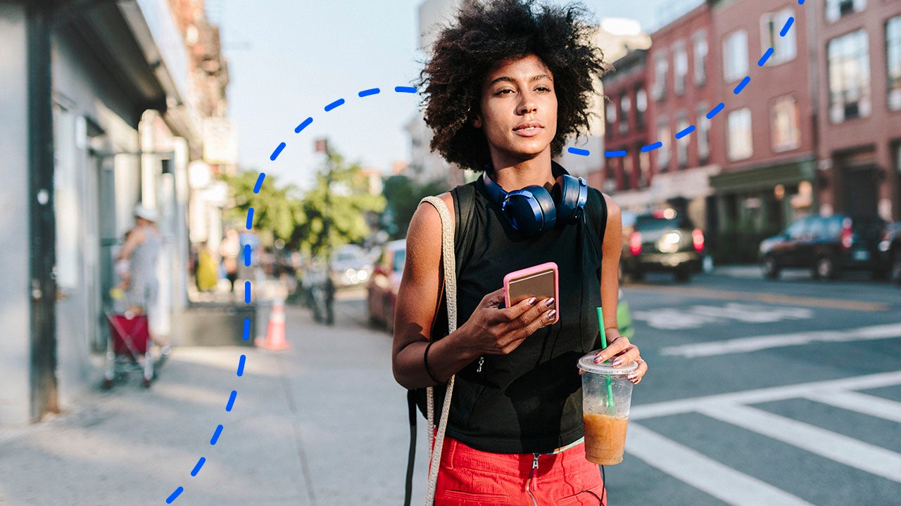 young person walking on an urban sidewalk