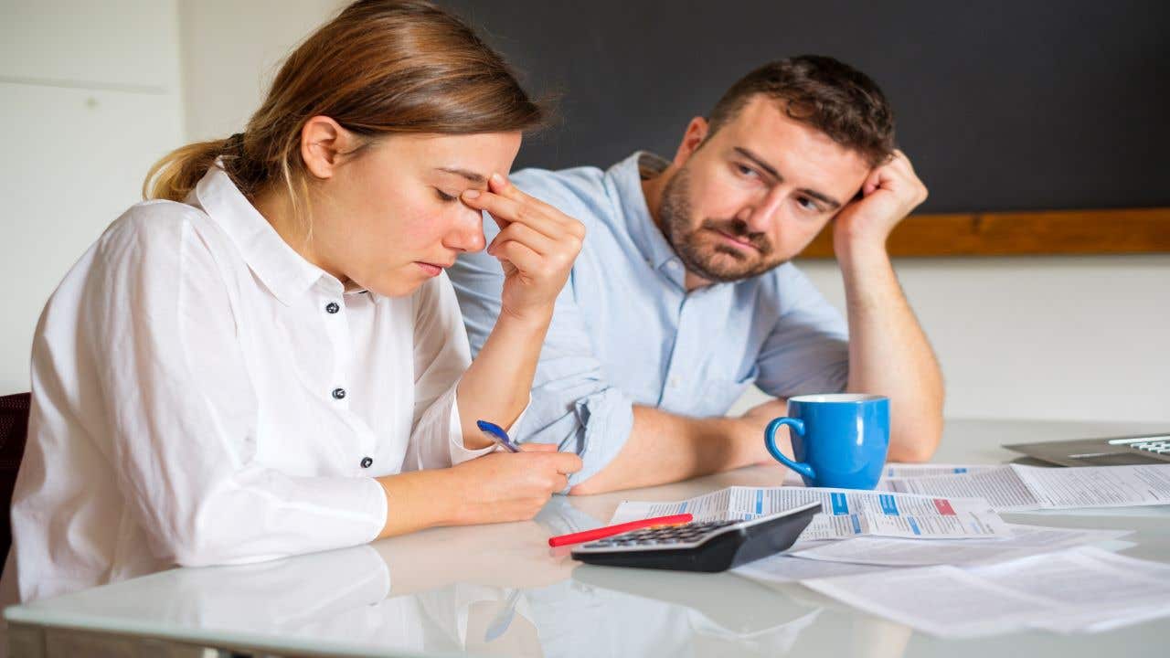 Couple looking stressed while analyzing finances.
