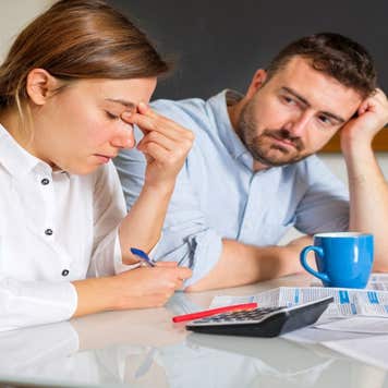 Couple looking stressed while analyzing finances.