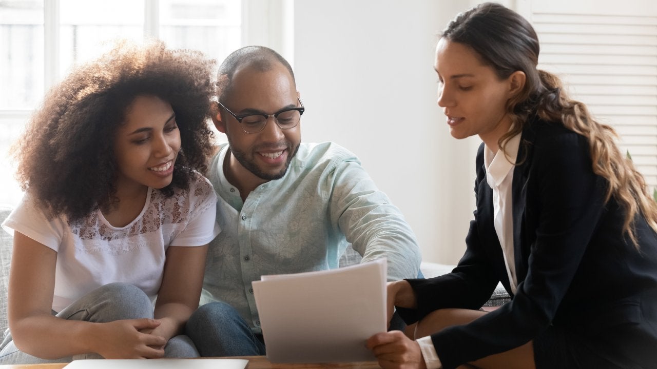 Couple discussing contract terms during meeting with realtor