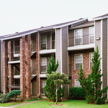 Front view of brick and siding condominium buildings from parking lot