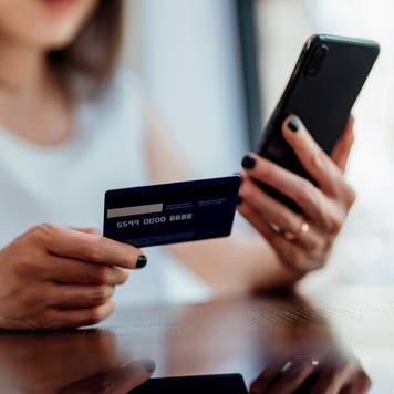 close up of hands holding credit card and phone