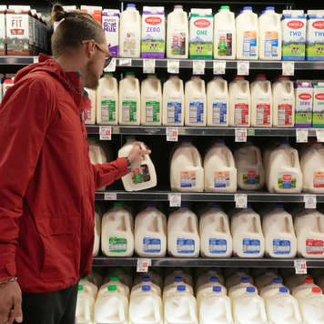 Shopper looks for milk at a grocery store