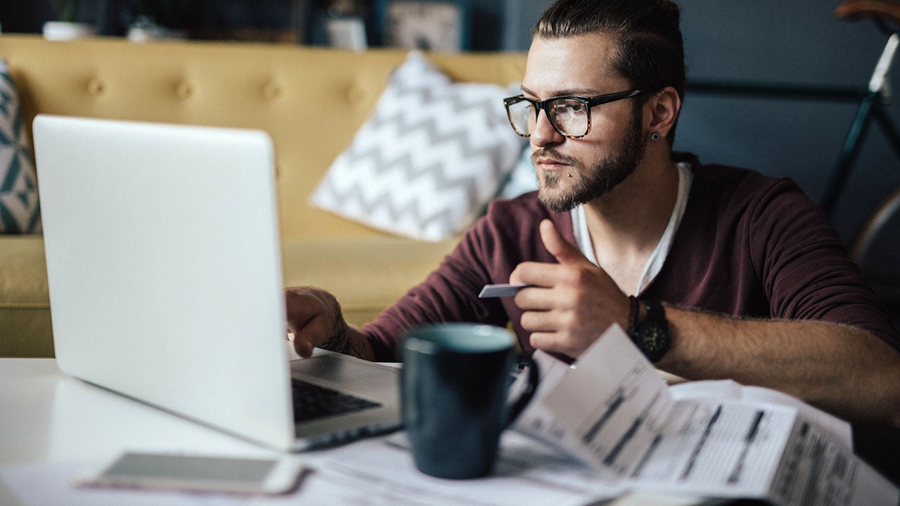 man paying bills online with a credit card