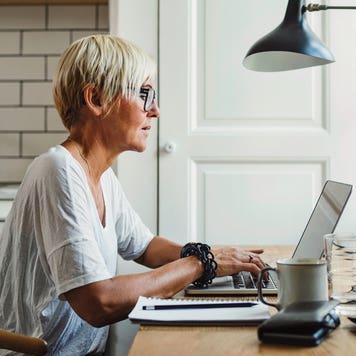 woman working on her laptop at a table in the kitchen