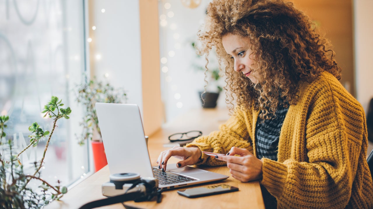 woman holding credit card and typing on laptop computer