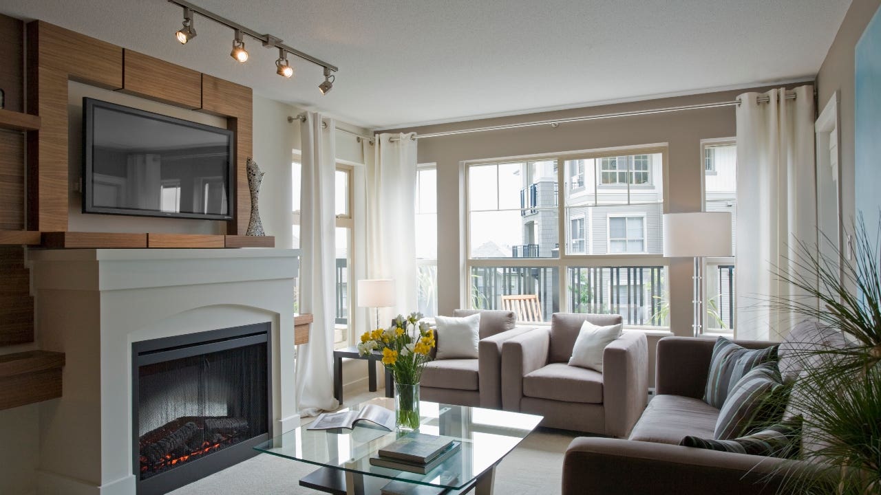 A contemporary furnished living room with fireplace and TV