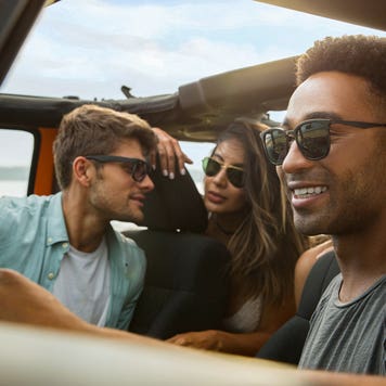 A group of friends driving in a jeep and having a good time.