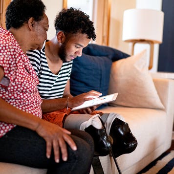 grandson using a digital tablet with his grandmother