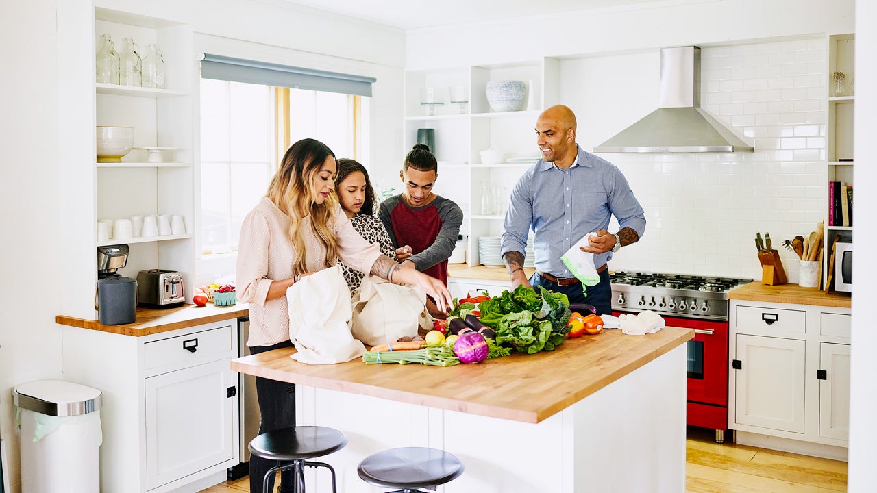 family unpacking groceries in the kitchen
