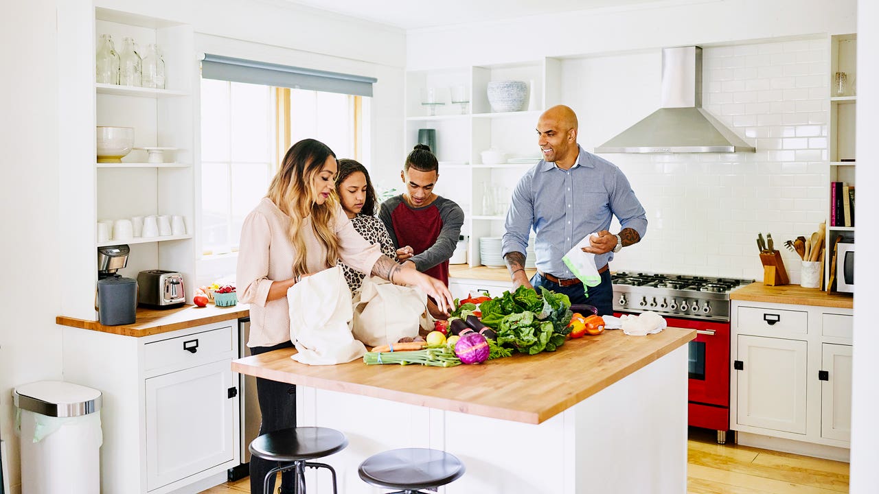 family unpacking groceries in the kitchen