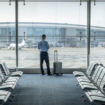 man looking out the window while waiting at an airport
