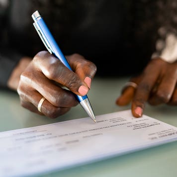 close up of hands writing a check