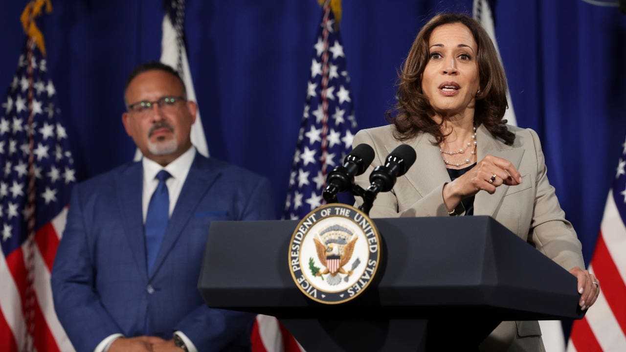 Kamala Harris and Miguel Cardona speak at a podium
