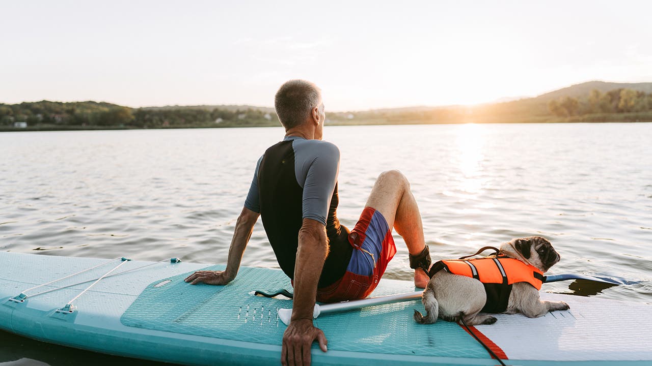 man sitting on surf board on lake