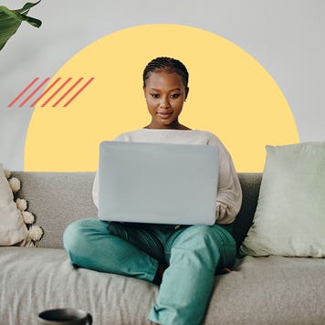 Young woman doing banking from her couch on a laptop