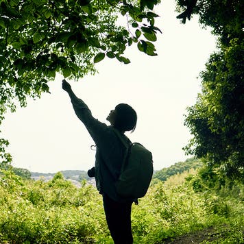 Senior woman looking at a map in the woods overlooking the city