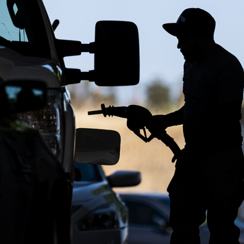 A customer holds a fuel nozzle at a Shell gas station in California