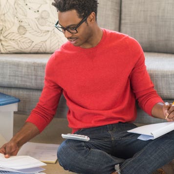 Man sits on the floor and works on paperwork