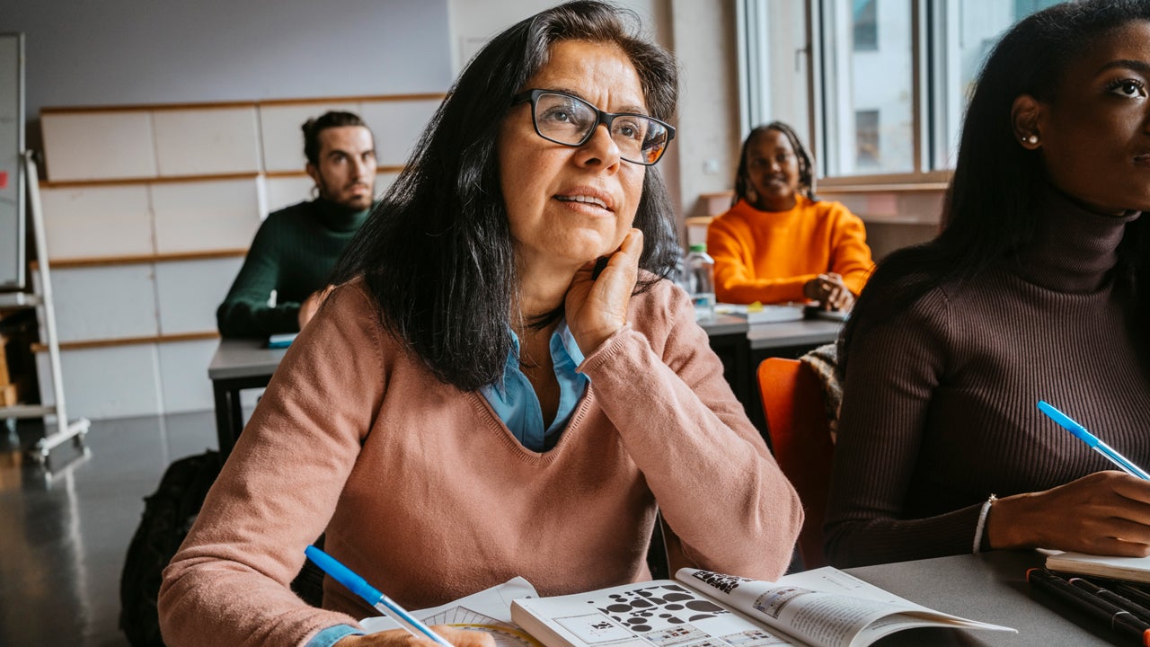older person at a desk looking to front of room