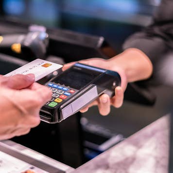 a person holding card next to card reader