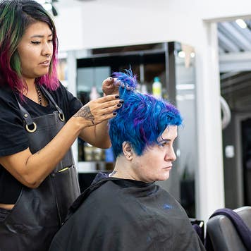 Hairdresser dyeing client's hair at hair salon
