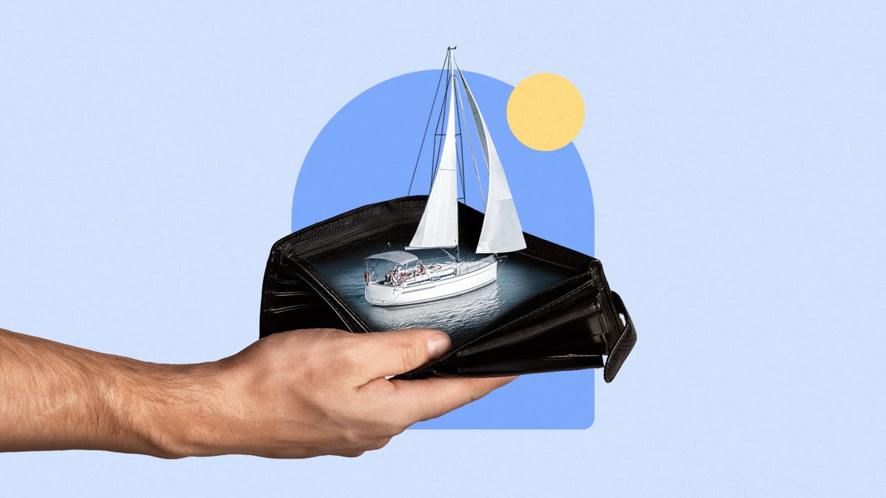 A hand holds a sailboat