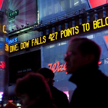 The Dow Jones ticker in Times Square displays news about the Dow closing below 8,000 at the end of the trading day in New York, U.S., on Wednesday, Nov. 19, 2008.