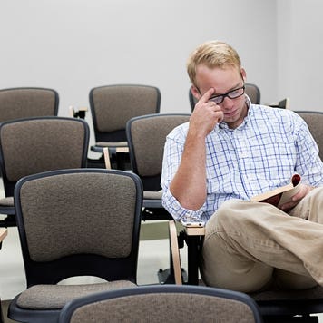 Student sits alone in classroom reading