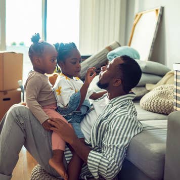 Close up of a father playing with his daughters in their new home