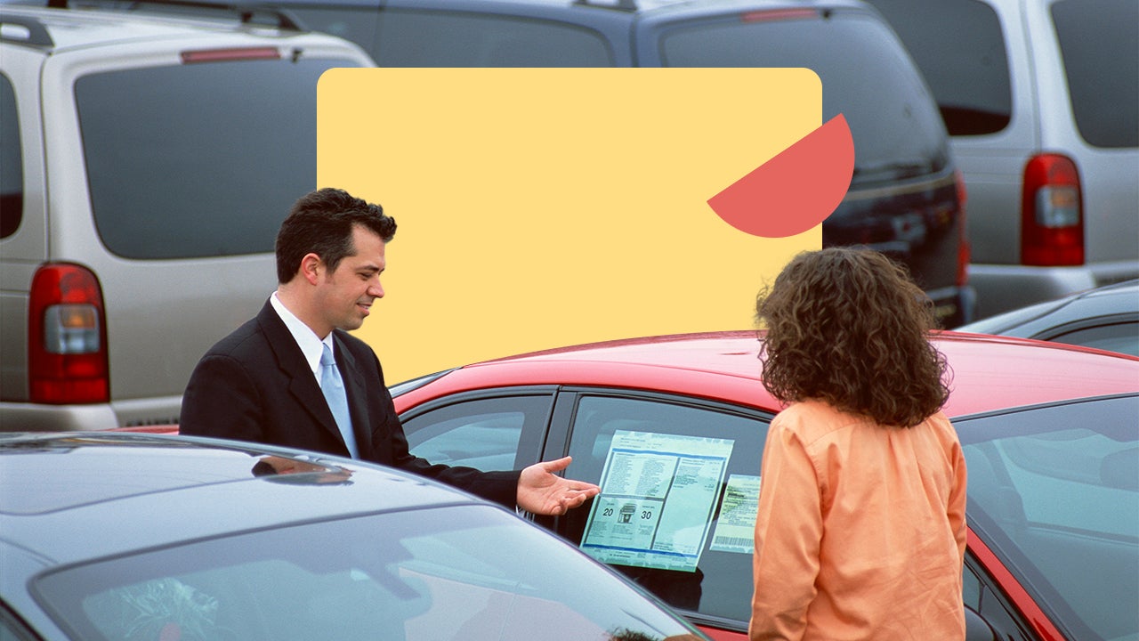 A car salesperson shows a vehicle to a buyer at a dealership.