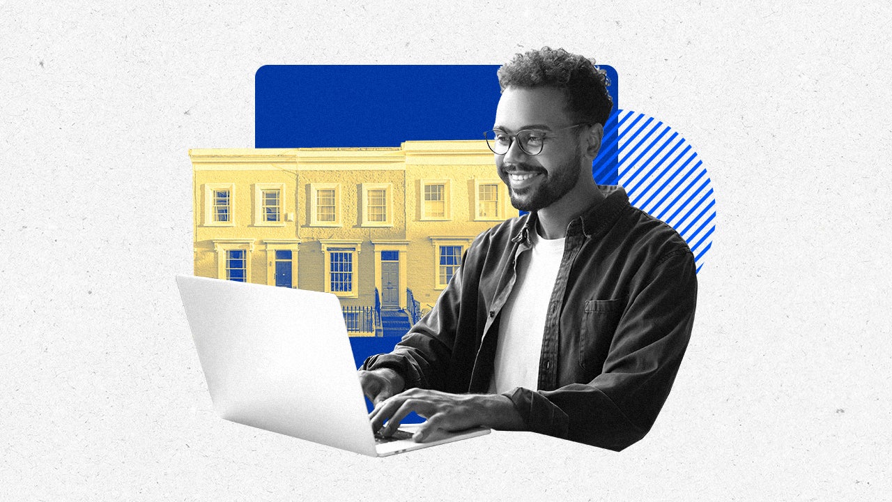 Person working on a laptop with buildings in the background.