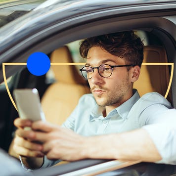 Person in a car that is parked and checking their phone.