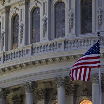 The American flag flies outside the U.S. Capitol before sunrise