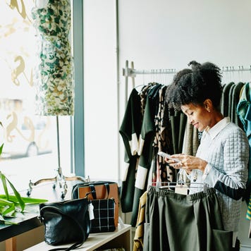 Woman checking smartphone while shopping