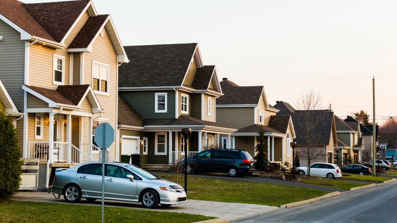 Line of suburb homes each with a car parked in the driveway