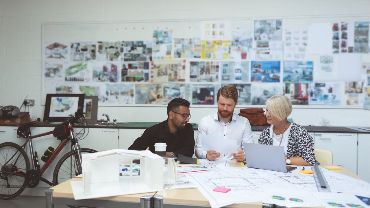 group of co-workers gathered at a table and discussing work